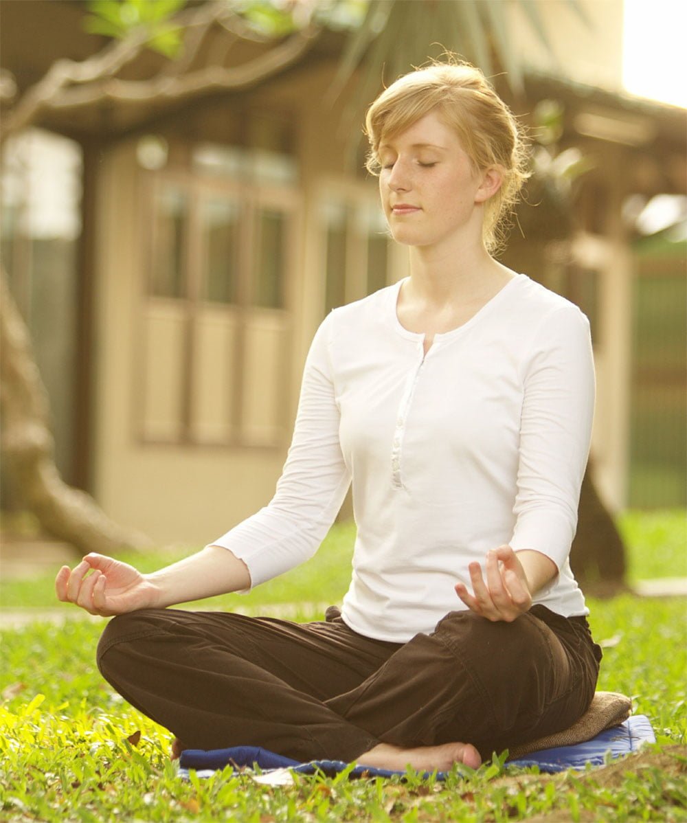 girl meditate sitting on grass