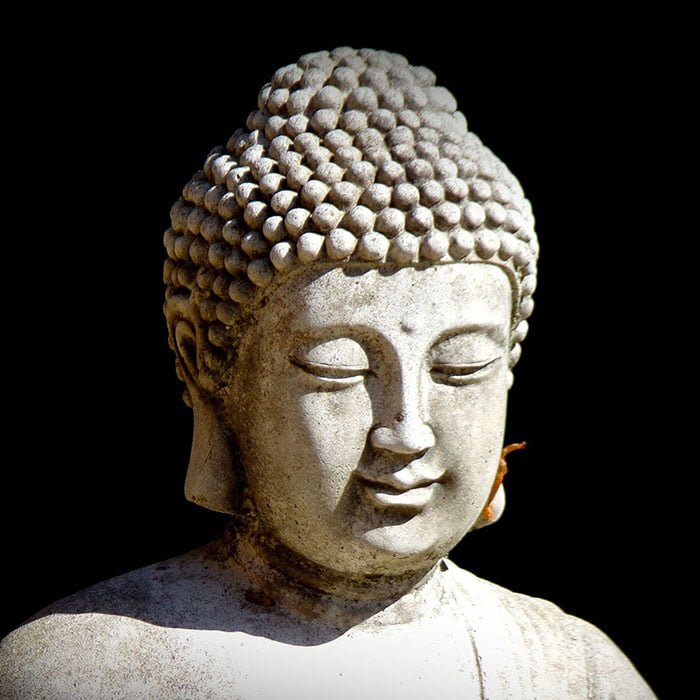 close up of buddha statue, black background