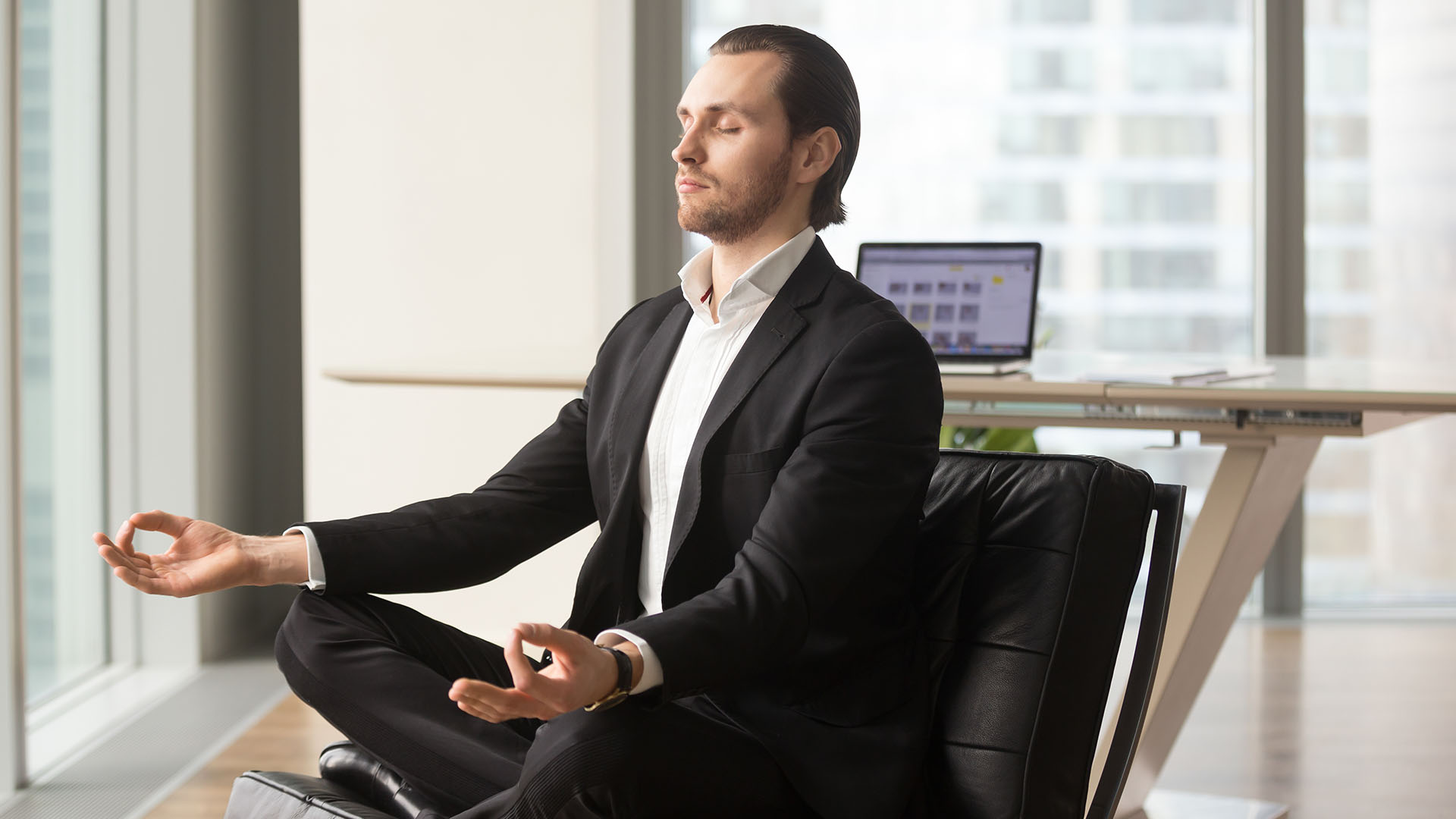 successful business man meditating in his office