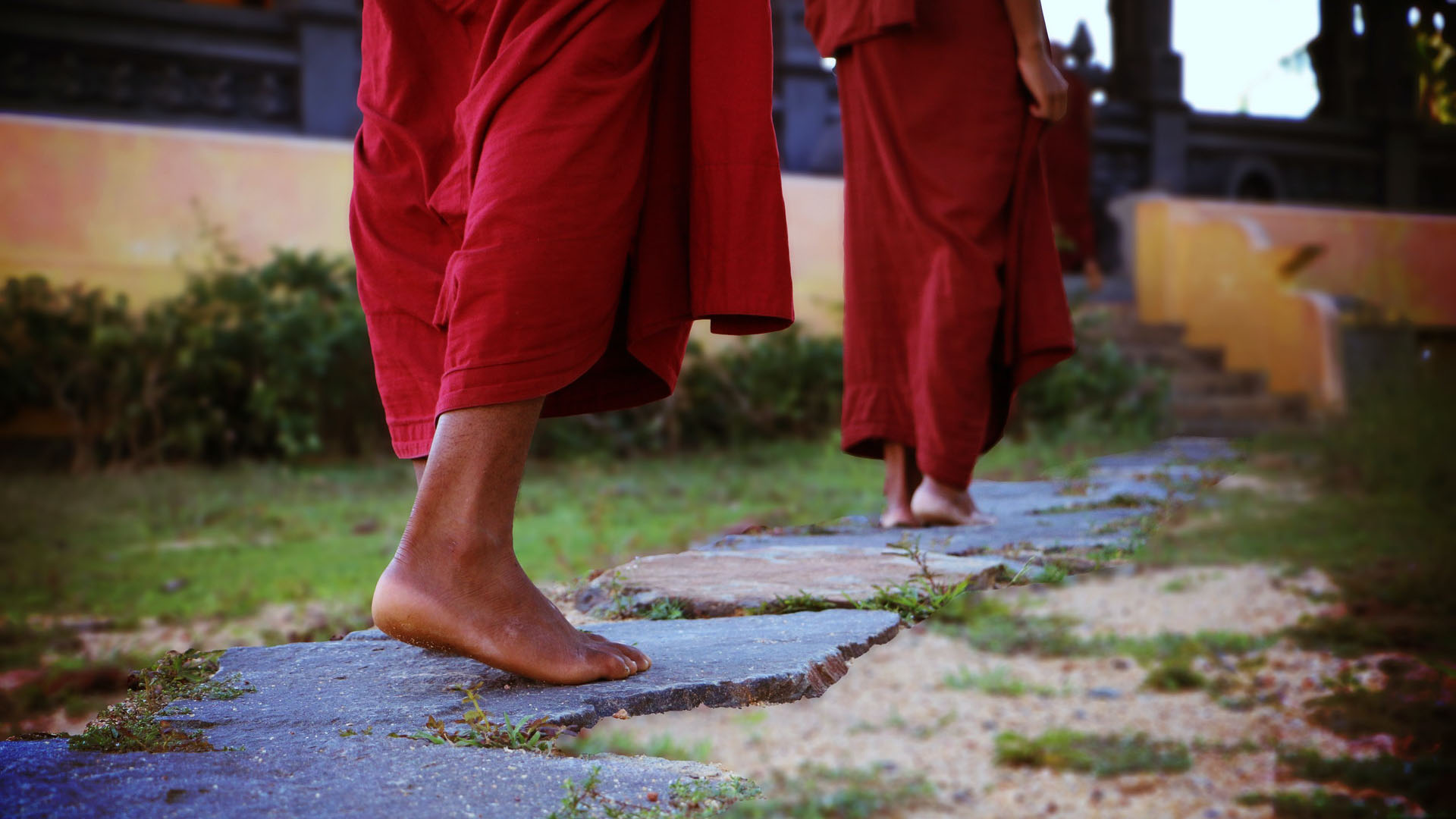 close up 2 monks' feet doing walking meditation